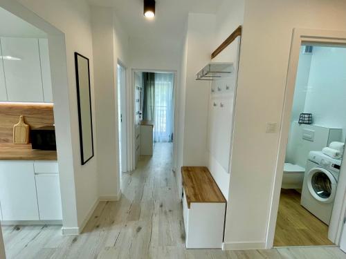 kuchnia i salon z białymi szafkami i stołem w obiekcie Apartament Jak Marzenie w mieście Ustrzyki Dolne