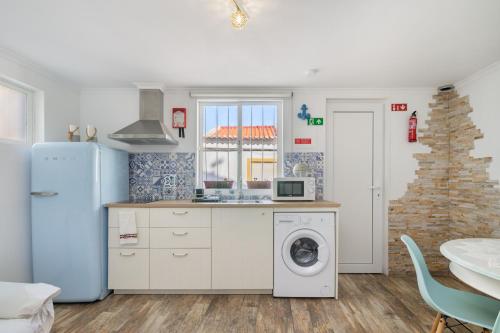 a kitchen with a refrigerator and a washing machine at Casa Cachalote in Ferragudo