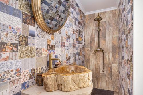 a bathroom with a wooden tub and a mirror at Casa Cachalote in Ferragudo