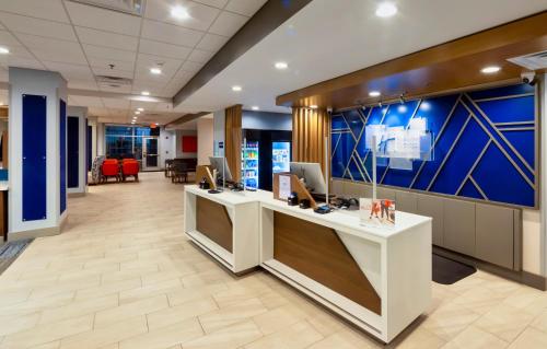 an office lobby with a desk with computers on it at Holiday Inn Express & Suites - Harrisonburg University Area by IHG in Harrisonburg
