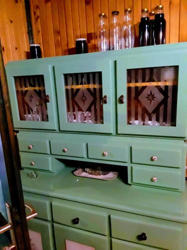 a green dresser with bottles on top of it at Medjedovica Brdo Godovik in Godovik