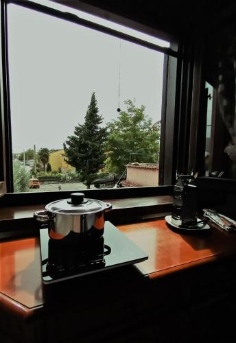 a pot on a stove in front of a window at B&B Home Holiday Villa delle Acacie agriturismo in Sala Consilina