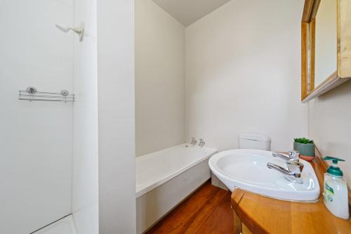 La salle de bains est pourvue d'un lavabo et d'une baignoire. dans l'établissement Pendreigh Cottage - Martinborough Holiday Home, à Martinborough