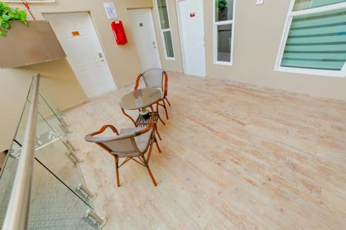 a room with two chairs and a table on a hard wood floor at Árbol Suites in Tijuana
