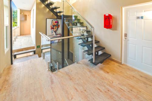 a glass staircase in a home with a red fire extinguisher at Árbol Suites in Tijuana