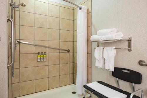 a bathroom with a shower with white towels at Holiday Inn Express Hotel & Suites Evanston, an IHG Hotel in Evanston