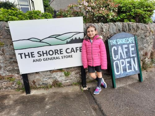 a little girl standing next to two signs at Firthview House in Kirn