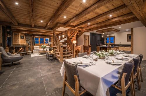 a large dining room with a table and chairs at Chalets Tâmo in Courchevel