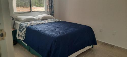 a small bed in a room with a window at Cancun Blue Airport in Cancún