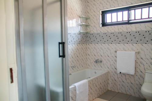 リロングウェにあるModern & secure apartment in Area 43 Lilongwe - self cateringのバスタブとトイレ付きのバスルーム