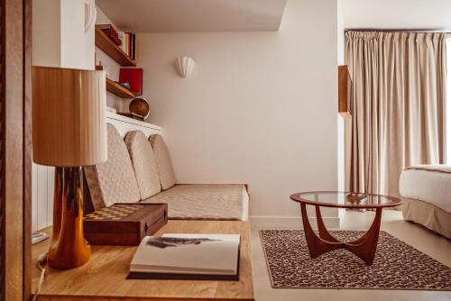 a living room with a bed and a table at Hôtel Monsieur Aristide in Paris