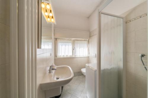 a bathroom with a sink and a toilet and a mirror at Casa Vista Cipressi in Varenna