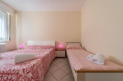 una camera con due letti con lenzuola rosa e una finestra di Casa Vista Cipressi a Varenna