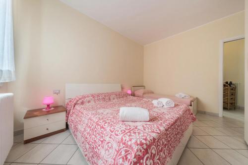 a bedroom with a bed with a red and white blanket at Casa Vista Cipressi in Varenna