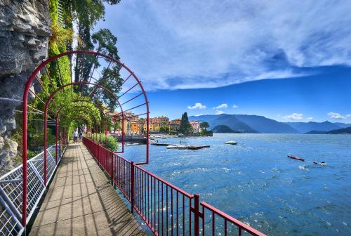 a walkway next to a body of water at The house with red sunsets in Varenna
