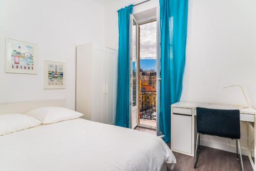 une chambre avec un lit, un bureau et une fenêtre dans l'établissement Modern 2-bedroom City Center Apartment, à Nice