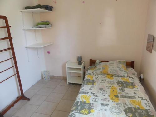 a small bedroom with a bed and a desk at Villa Fleurs Amande in Marigot