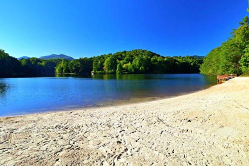 a sandy beach with a view of a lake at The Crows Nest in Lake Lure