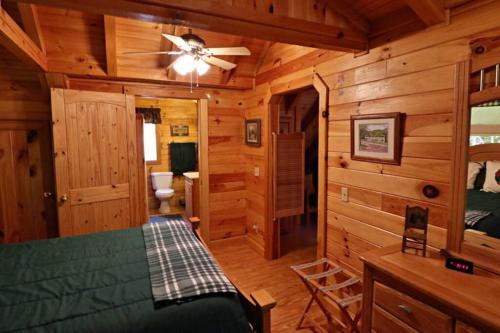 W domku znajduje się sypialnia z łóżkiem i wentylatorem sufitowym. w obiekcie The Crows Nest w mieście Lake Lure