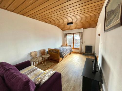een woonkamer met een paarse bank en een bed bij Casa Andina in Bariloche