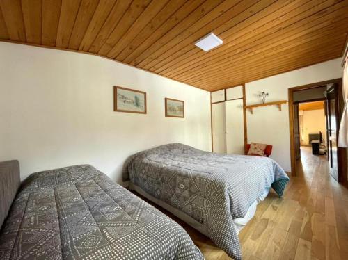 een slaapkamer met 2 bedden en een houten plafond bij Casa Andina in Bariloche
