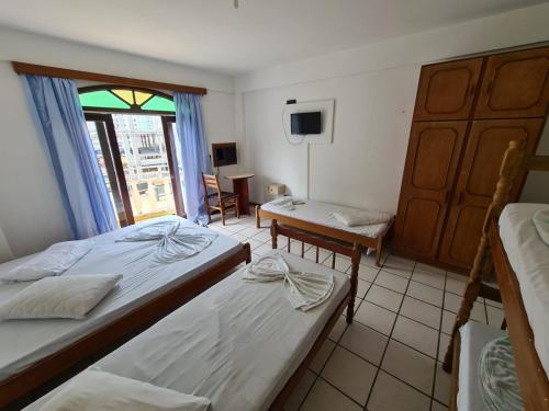 um quarto com duas camas e uma mesa e uma janela em HOTEL VISUAL em Balneário Camboriú