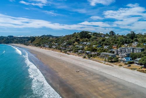 an aerial view of a beach with houses at The Sands - Apartment 19 - Stay Waiheke in Onetangi