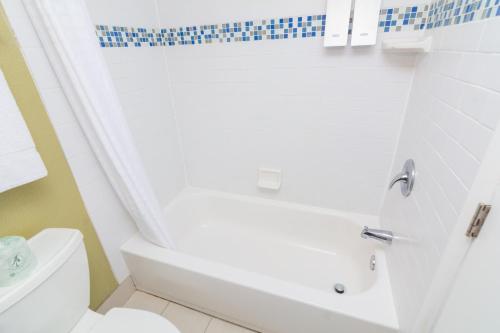 een badkamer met een wit bad en een toilet bij Beach House Dewey in Dewey Beach