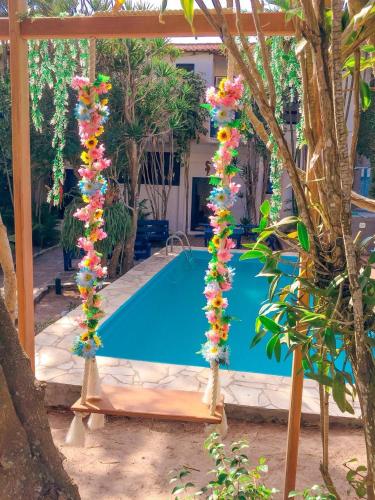 a pool in front of a house with flowers at Pousada Bicho do Mar in Arraial do Cabo