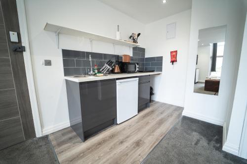 a kitchen with a sink and a counter top at The Ashcroft Apartments Free Parking in Manchester