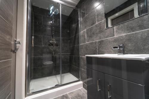 a bathroom with a shower and a sink at The Ashcroft Apartments Free Parking in Manchester