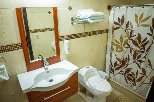 y baño con lavabo, aseo y ducha. en Hotel Santa Fe, en Santa Rosa de Copán
