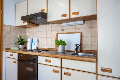 a kitchen with white cabinets and a sink at Knusthof - Wohnung 1 in Albertsdorf