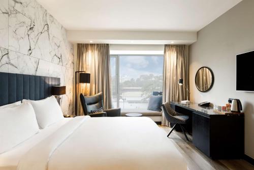 Una habitación de hotel con una cama grande y un escritorio. en Radisson Blu Anchorage Hotel, en Lagos
