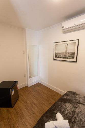 a room with a bed and a picture on the wall at Hostel More SP in Sao Paulo