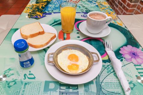 a breakfast of eggs and bread and coffee on a table at Ayenda Puerto Madero Boutique in Chía