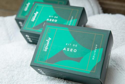 three green boxes sitting on top of a white towel at Ayenda Puerto Madero Boutique in Chía