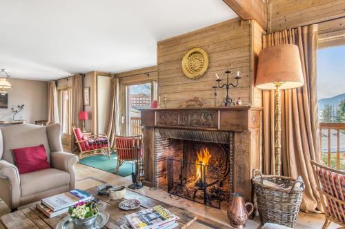 a living room with a fireplace in a house at L'Écrin Alpin - Welkeys in Megève