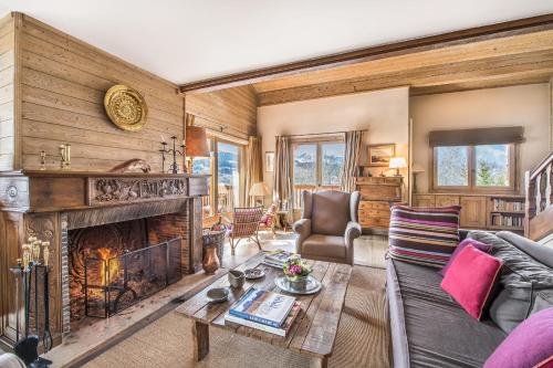 a living room with a couch and a fireplace at L'Écrin Alpin - Welkeys in Megève
