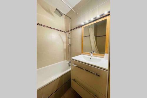 a bathroom with a sink and a tub and a mirror at Bel appartement bord de mer 4 pers Arcachon centre in Arcachon