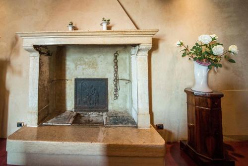 a fireplace with a vase of flowers on a table at Hotel Remàt in Garda