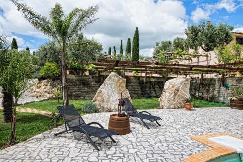 a patio with two chairs and a pool at Il Giardino dei Flintstones B&B in Cerveteri