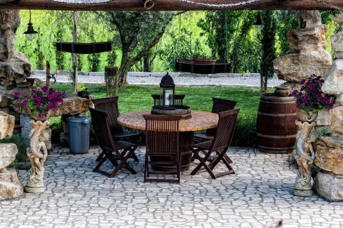 a patio with a table and chairs on a patio at Il Giardino dei Flintstones B&B in Cerveteri