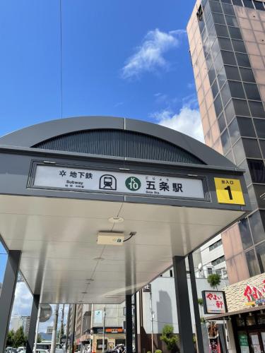 a sign in front of a building in a city at HOTEL TAVINOS Kyoto in Kyoto