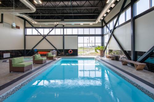 a large swimming pool with chairs and tables in a building at Wingate by Wyndham Kanata West Ottawa in Ottawa