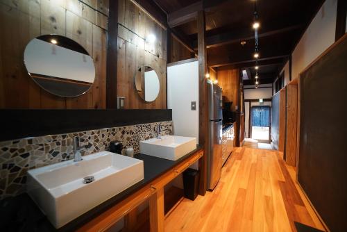 a bathroom with two sinks and a mirror at WATOWA in Yunotu