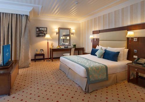 a hotel room with a large bed and a television at Premier Le Reve Hotel & Spa Sahl Hasheesh - Adults Only 16 Years Plus in Hurghada