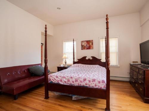 1 dormitorio con cama con dosel y sofá en The Windsor Inn, en Cambridge