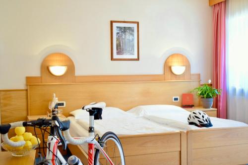 a bedroom with a bed with a bike in it at Hotel Waldheim in Sarnonico