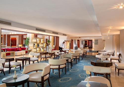 a restaurant with tables and chairs in a hotel at Premier Le Reve Hotel & Spa Sahl Hasheesh - Adults Only 16 Years Plus in Hurghada